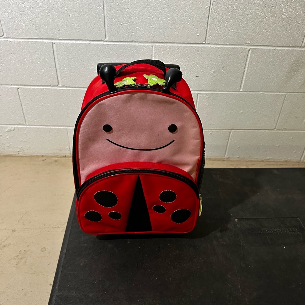 Skip Hop Red and Black Ladybug Kids rolling suitcase with strap